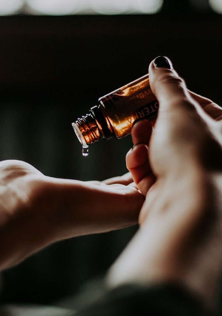 person holding amber glass bottle
